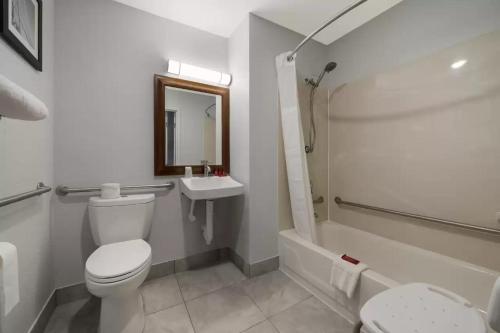 a white bathroom with a toilet and a sink at Quality Inn West Lafayette - University Area in Lafayette