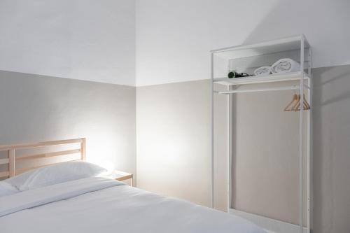 a white bedroom with a bed and a small refrigerator at Duomo Apartment in Florence
