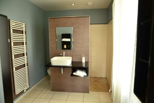a bathroom with a sink and a mirror at Vaste Maison de 300 m2 en forme de bateau pour 15 L'Iliade in Port-en-Bessin-Huppain