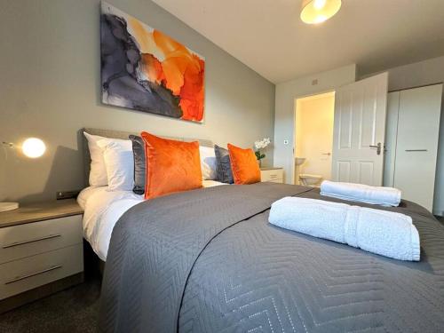a bedroom with two beds with orange pillows at Densham House by Blue Skies Stays in Stockton-on-Tees