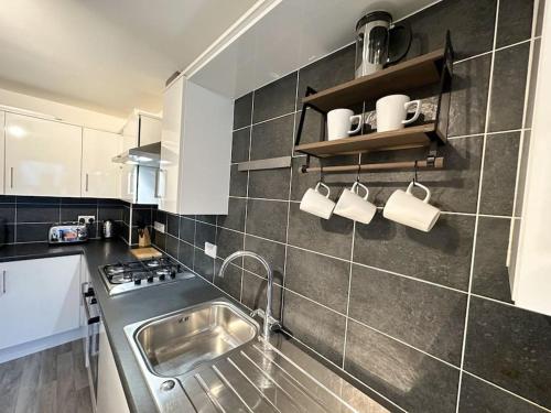 a kitchen with a sink and a stove top oven at Densham House by Blue Skies Stays in Stockton-on-Tees