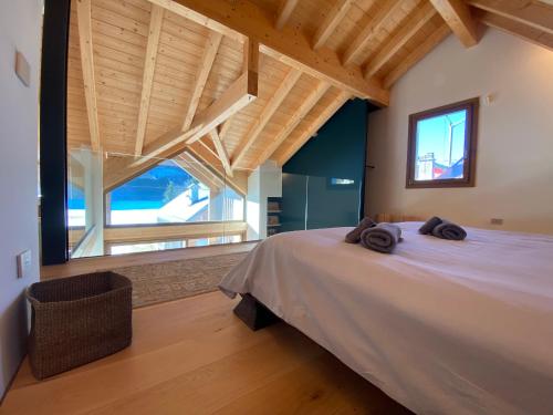 1 dormitorio con 1 cama grande y ventana grande en Luxury Chalet in the Tarvisio mountains, en Camporosso in Valcanale