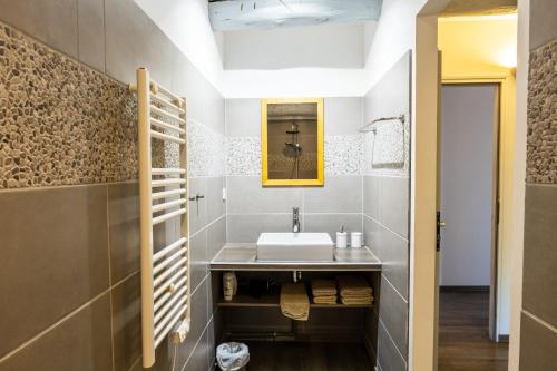 bagno con lavandino e specchio di Mas d'Alaure B&B a Verquières