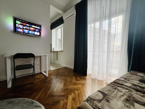 a bedroom with a bed and a table and a window at Kyiv Old Town Apartment near Golden Gate in Kyiv
