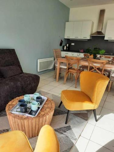 un salon avec un canapé et une table avec des chaises dans l'établissement Appart magnifique avec une vue exceptionnelle OLERON, à La Bernerie-en-Retz