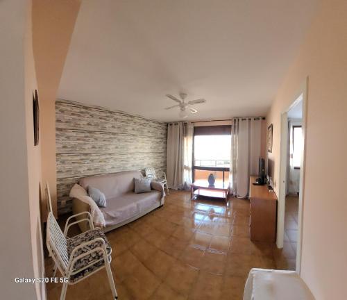 un soggiorno con divano e muro di mattoni di Colóm vacaciones felices a Salou