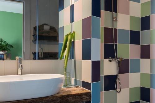 a bathroom with a tub and a sink and a mirror at Altanure Almatere - Food Forest Boutique Stay in Tavira