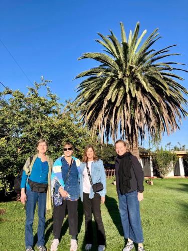 a group of people standing in front of a palm tree at Hosteria Casa Silva in Checa