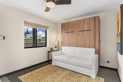 ein Wohnzimmer mit einem weißen Sofa und einem Fenster in der Unterkunft Midtown Marvel: Trendy Studio in the Heart of Reno in Reno