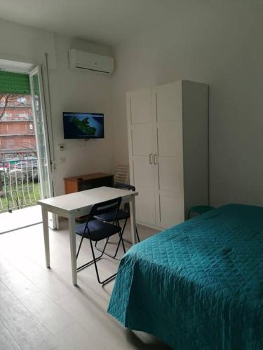 1 dormitorio con cama, mesa y escritorio en Monolocale Ostia locaz.turistica, en Lido di Ostia