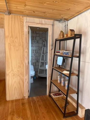 a room with a book shelf and a toilet at Casa Vaguada Laguna Verde in Laguna Verde