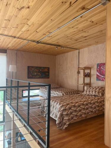 a bedroom with a bed and a wooden ceiling at Casa Vaguada Laguna Verde in Laguna Verde