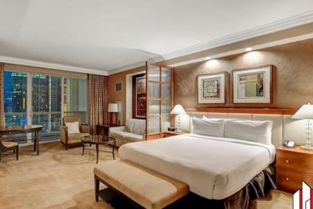 a bedroom with a large bed and a living room at MGM Signature-15-717 F1 Track & Strip View Balcony in Las Vegas