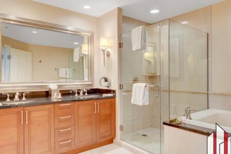 a bathroom with a shower and a sink and a tub at MGM Signature-15-717 F1 Track & Strip View Balcony in Las Vegas