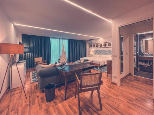 a living room with a couch and a bed and a desk at Club del Sole Tenuta Primero Grado Family Collection in Grado
