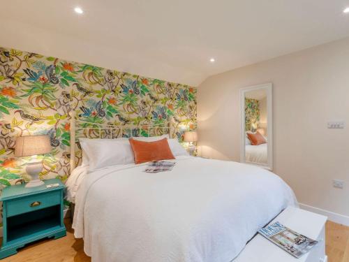 a bedroom with a white bed and a floral wall at 1 Bed in Sherborne 83499 in Wincanton