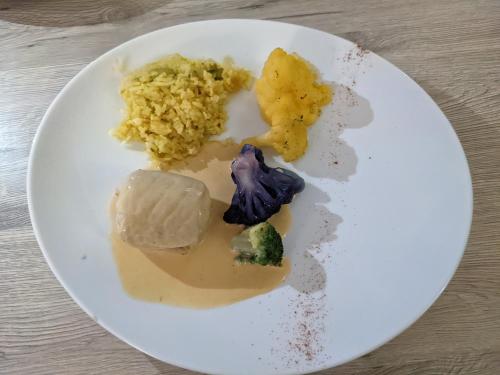 une assiette de nourriture avec du brocoli de riz et d’autres denrées alimentaires dans l'établissement L'Hôtel du Lac Casteljaloux, à Casteljaloux