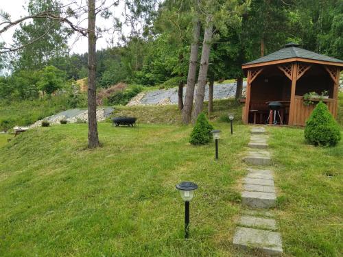 a garden with a gazebo and a cow in a field at Noclegi Ostoja Gromadzyń in Ustrzyki Dolne