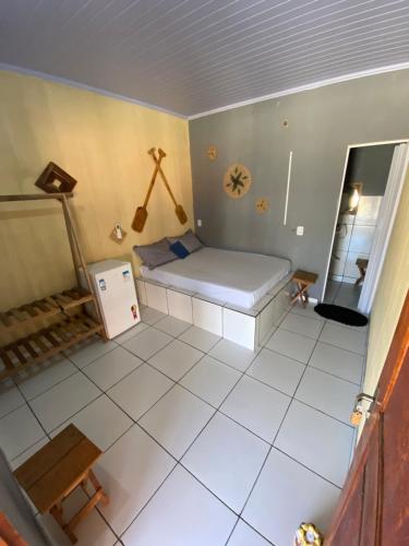 a small room with a bed and a tiled floor at Pousada rancho sol nascente in Tutóia