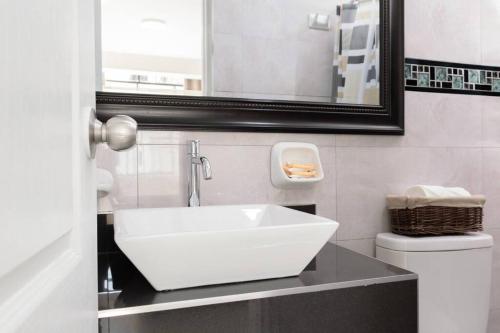 W łazience znajduje się biała umywalka i lustro. w obiekcie Residencial Suiza w mieście Lima