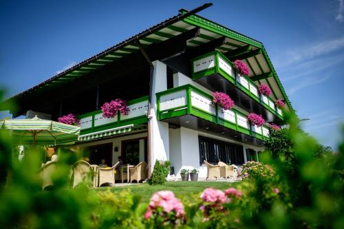 a building with pink flowers on the balconies of it at Landhaus am Stein in Bad Wiessee