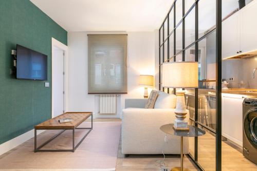 - un salon avec un canapé et une table dans l'établissement PLAZA DE CASTILLA Apartments, à Madrid
