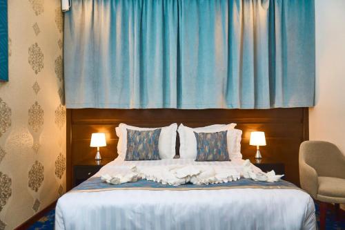 a bedroom with a bed with a blue curtain at Selat Al Bait Hotel in Makkah