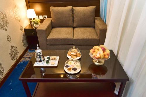 a living room with a couch and a table with food at Selat Al Bait Hotel in Makkah