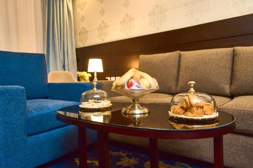 a living room with a couch and a table with food on it at Selat Al Bait Hotel in Makkah