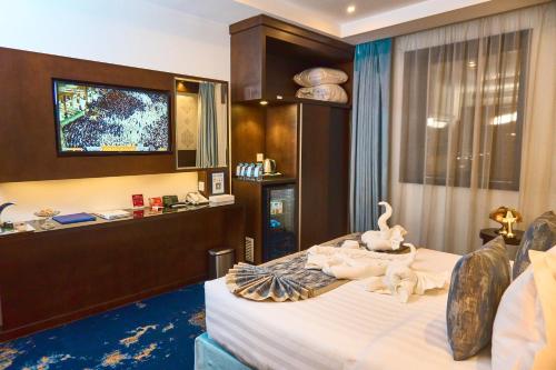 a hotel room with a bed with a tv on it at Selat Al Bait Hotel in Makkah