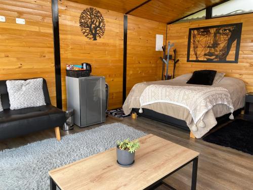 a bedroom with a bed in a wooden cabin at ECO CABAÑAS EL ABUELO in La Calera
