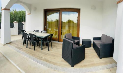 uma sala de jantar com mesa e cadeiras em Mauris Home em Tortolì