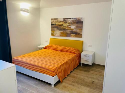 a bedroom with a bed with an orange blanket at Mauris Home in Tortolì