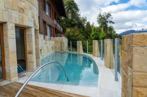 uma piscina com uma rampa que leva a um edifício em El Faro Boutique Hotel & Spa by DON em Villa La Angostura