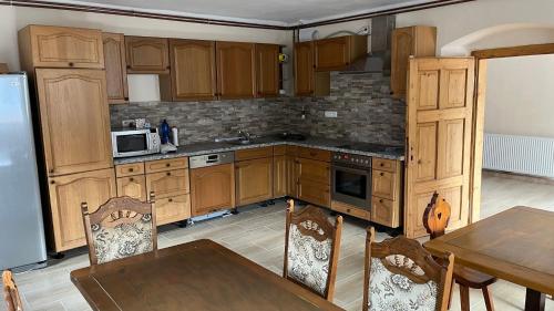 a kitchen with wooden cabinets and a table with chairs at Marcelína in Mikulov v Krušných Horách