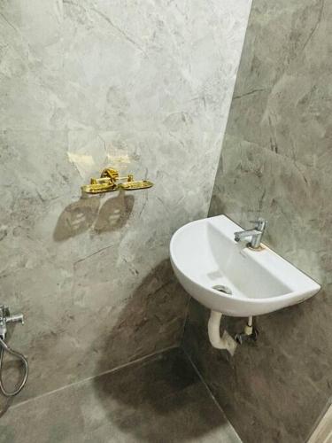a bathroom with a white sink in a wall at Simhagiri Sea Holiday Inn in Visakhapatnam