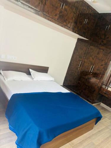 a bedroom with a bed with a blue blanket on it at Simhagiri Sea Holiday Inn in Visakhapatnam