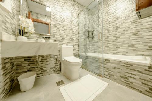 a bathroom with a toilet and a sink and a tub at Chic Apartment Dubai Marina in Dubai