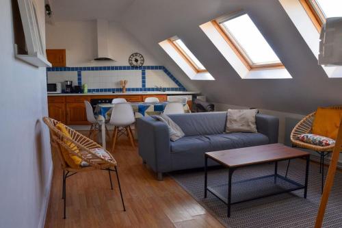 un salon avec un canapé et une table dans l'établissement Camelia; Beau logement lumineux, avec vue sur mer, à Wimereux