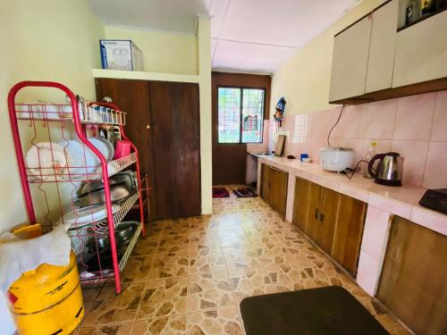 a kitchen with a red cart in the middle of it at Doranagala Holiday Home in Matale