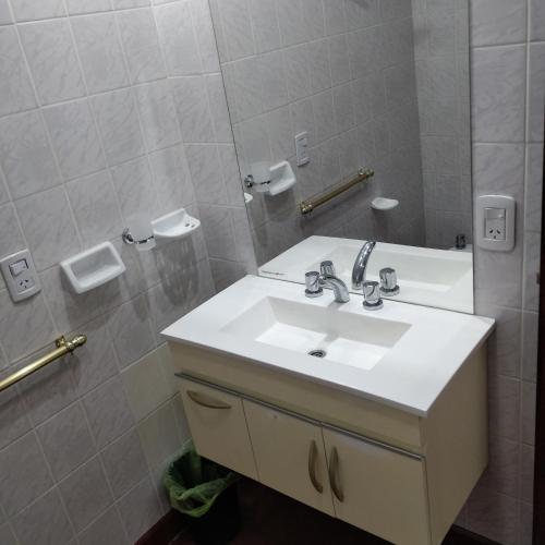 bagno con lavandino bianco e specchio di Rosa Ramona Rooms a San Salvador de Jujuy