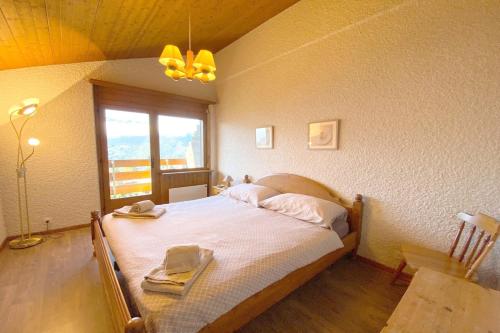 um quarto com uma cama num quarto com uma janela em Tourtereaux 223 em Verbier