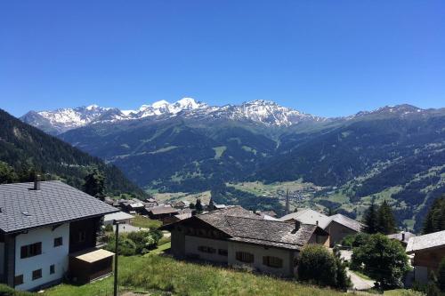 a village with snow capped mountains in the background at Tourtereaux 223 in Verbier