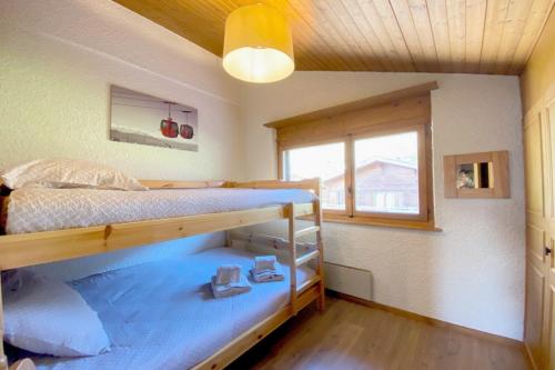 a bedroom with two bunk beds and a window at Tourtereaux 223 in Verbier