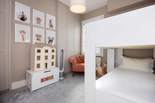 - une chambre avec un lit blanc et une chaise dans l'établissement Veeve - A Symphony in Green, à Londres