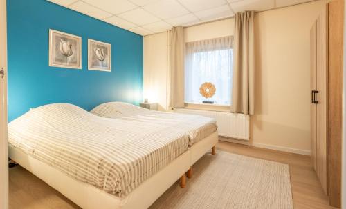 - une chambre dotée d'un lit avec un mur bleu dans l'établissement Appartementen Zuiderstrand Zoutelande, à Zoutelande