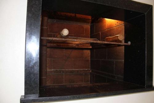 a glass oven with a shelf in a wall at Residencial Ferrugem Beira Mar in Garopaba