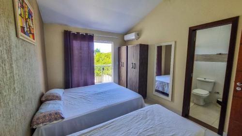 1 dormitorio con 2 camas y ventana en Ferrugem Beira Mar, en Garopaba