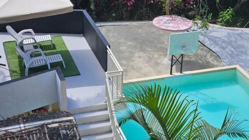 an overhead view of a pool with chairs and a table at A touch of Pink secret garden in Puerto Princesa City