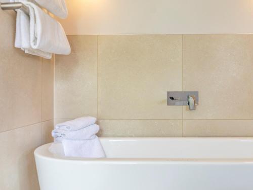 y baño con bañera y toallas. en 2 Bed in St. Mellion 87706, en St Mellion